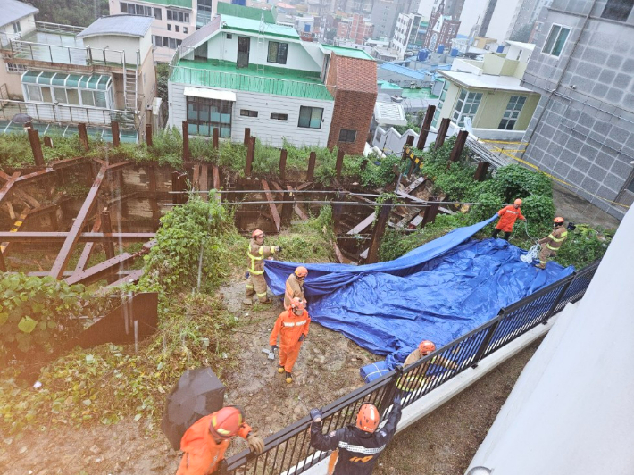 부산진구의 한 공사장에서 토사가 흘러내려가 소방당국이 안전 조치에 나선 모습. 부산소방재난본부 제공 