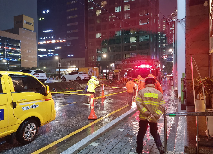 18일 부산에 많은 비가 내려 해운대구의 한 도로에 땅거짐 현상(싱크홀)이 발생했다. 부산소방재난본부 제공