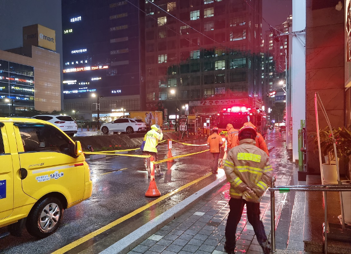 18일 부산에 많은 비가 내려 해운대구의 한 도로에 땅거짐 현상(싱크홀)이 발생한 모습. 부산소방재난본부 제공