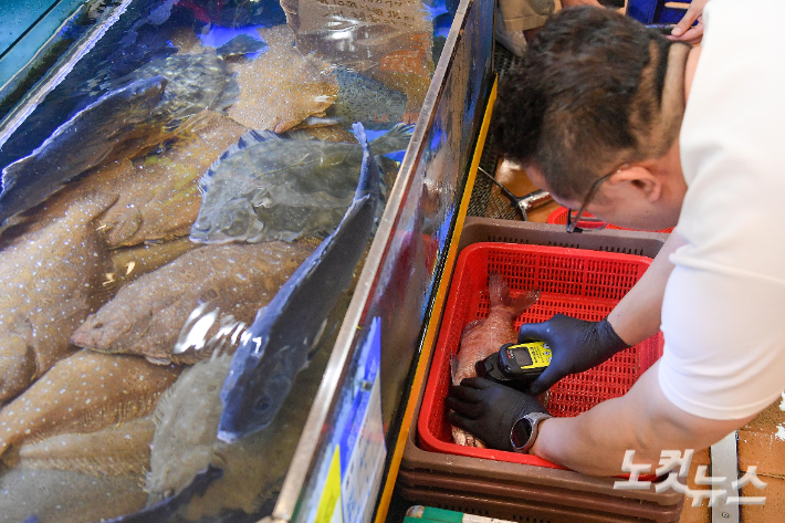 수산시장에서 직원이 일본산 수산물에 대한 방사능 검사를 하고 있다. 박종민 기자