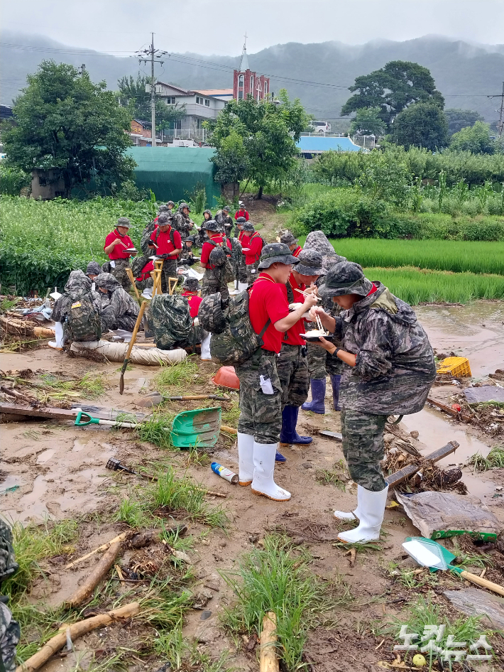 지난 17일 산사태 피해 지원에 나선 해병대원들이 잠시 수색을 멈추고 빗속에서 늦은  식사를 하고 있다. 정인효 기자