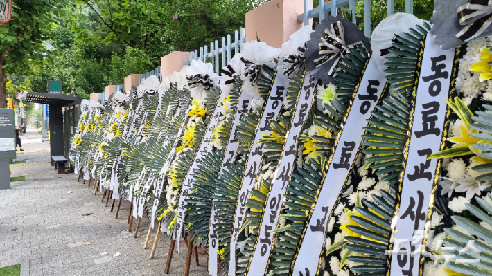 20일 오전 8시쯤 서울 서초구 한 초등학교 주변으로 추모 화환들이 길게 늘어져 있었다. 양형욱 기자