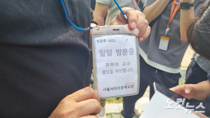 한 교사가 학교로부터 발급받은 일일 방문증을 보여주고 있다. 양형욱 기자