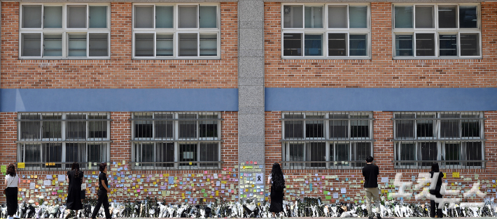 21일 오전 서초구 한 초등학교에 마련된 교사 A씨의 추모공간에 시민들이 헌화를 하고 있다. 황진환 기자