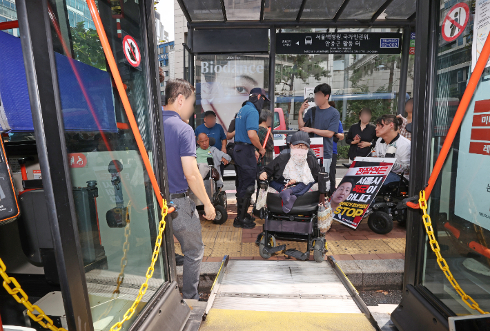 25일 오전 서울 중구 국가인권위원회 인근 버스정류장에서 전국장애인차별철폐연대가 연 '제17차 버스행동'에서 활동가들이 저상버스에 타고 있다. 연합뉴스