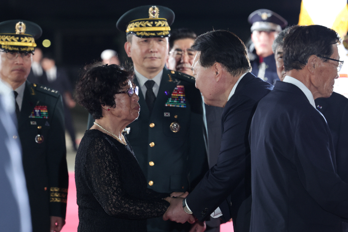 윤석열 대통령이 26일 밤 경기 성남 서울공항에서 열린 6·25 전쟁 국군전사자 유해봉환 행사에서 고 최임락 일병의 유족을 위로하고 있다. 대통령실 제공