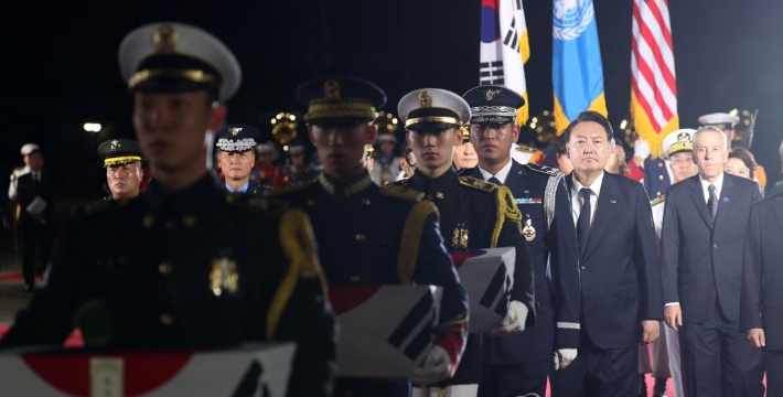 윤석열 대통령이 26일 밤 경기 성남 서울공항에 도착한 6·25 전쟁 국군전사자 유해 봉송 행렬에 따라나서고 있다. 연합뉴스