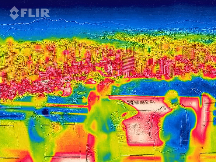 지난달 30일 오후 서울 남산에서 열화상카메라로 촬영한 도심 모습. 사진 속 높은 온도는 붉은색, 낮은 온도는 푸른색으로 표시된다. 연합뉴스