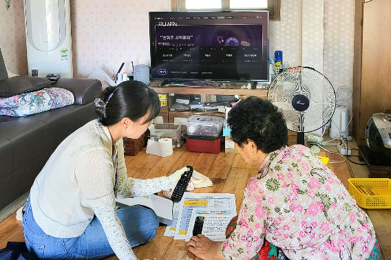 진도군보건소 직원이 '지니 TV 케어' 서비스 사용 방법을 어르신에게 알려주고 있다. KT 제공