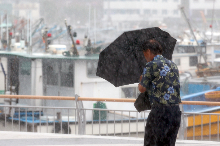 10일 오전 경남 통영시 강구안 주변에서 우산을 쓴 시민이 걸어가고 있다. 연합뉴스