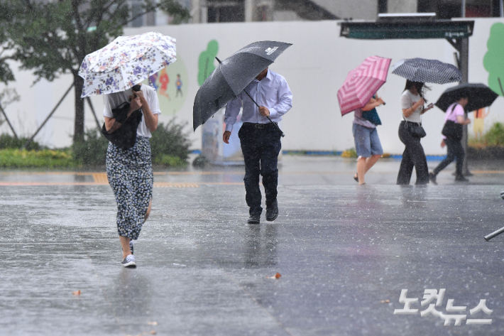 제6호 태풍 '카눈'이 상륙하면서 한반도 전역이 직접적인 영향권에 들어간 10일 서울 종로구 광화문 광장에서 시민들이 비바람을 맞으며 발걸음을 옮기고 있다. 류영주 기자