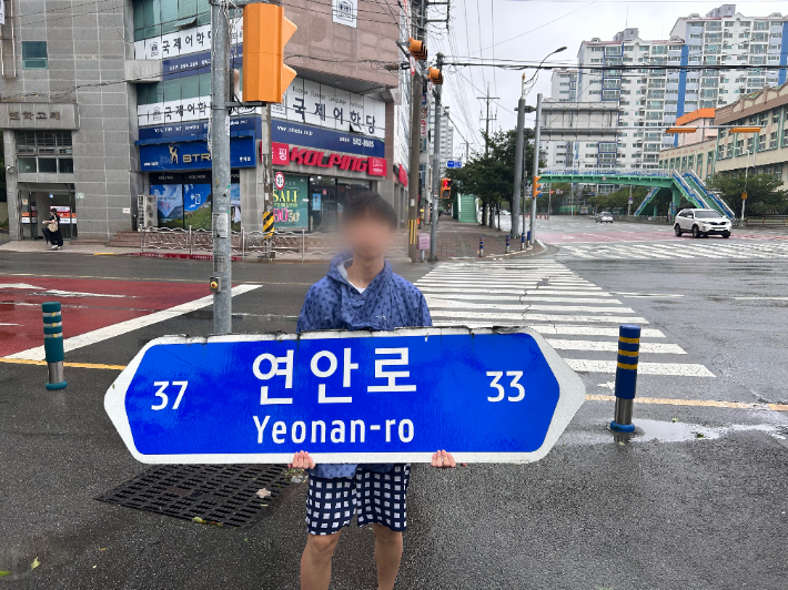 부산 동래구 연안로 일대에서 한 남성이 강풍으로 날아간 표지판을 들고 있다. 네이버 날씨 'sam' 제공