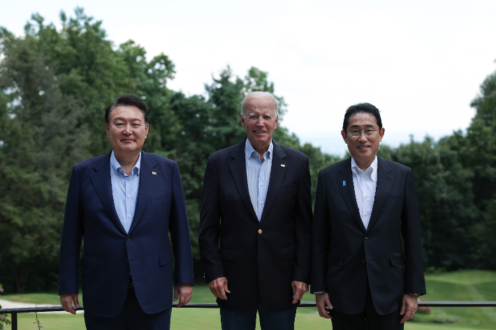 윤석열 대통령과 조 바이든 미국 대통령, 기시다 후미오 일본 총리가 18일(현지시간) 워싱턴DC 인근 미국 대통령 별장인 캠프 데이비드에서 열린 오찬에서 기념촬영을 하고 있다. 연합뉴스