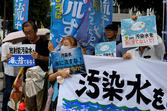22일(현지시간) 도쿄 총리실 밖에서 일본 시민들이 "방사능 오염수를 바다에 버리지 마세요" 등이 적힌 팻말을 들고 오염수 방류 계획에 반대하는 시위를 하고 있다. 연합뉴스
