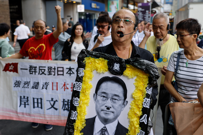 24일(현지시간) 홍콩에서 시위대가 기시다 후미오 일본 총리의 사진을 들고 오염수 방류를 반대하고 있다. 연합뉴스