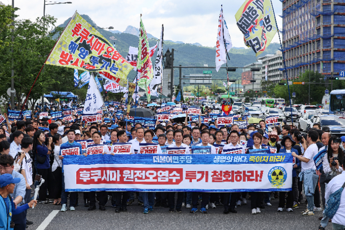 더불어민주당 의원들이 25일 오전 서울 종로구 광화문광장에서 후쿠시마 원전 오염수 투기 중단을 촉구하며 대통령실 방향으로 행진하고 있다. 연합뉴스