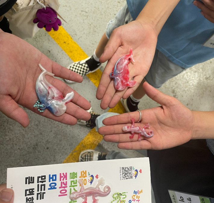 '플라스틱 방앗간 인 부산'에서 운영하는 업사이클링 공장을 찾은 아이들이 직접 수거한 병뚜껑을 업사이클링해 만든 열쇠고리를 자랑하고 있다. 사상구청소년수련관 제공