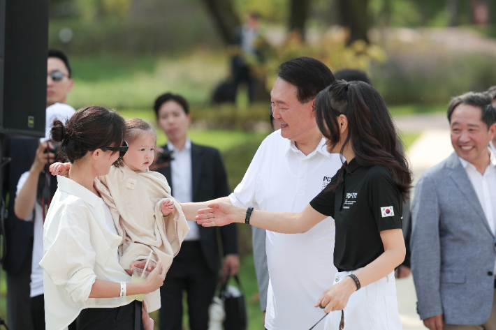 윤석열 대통령과 김건희 여사가 26일 서울 용산어린이정원 내 조성된 분수정원에서 열린 다둥이가족 초청행사에 깜짝 방문, 어린이와 인사를 나누고 있다. 대통령실 제공