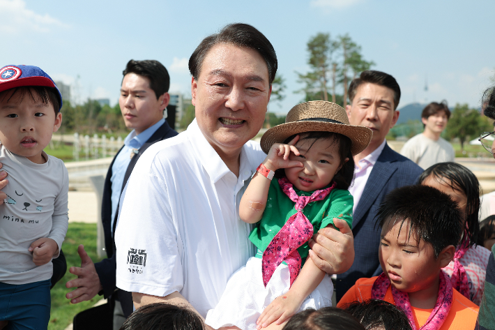 윤석열 대통령이 26일 서울 용산어린이정원 내 조성된 분수정원에서 열린 다둥이가족 초청행사에 깜짝 방문, 어린이들과 기념사진을 찍고 있다. 대통령실 제공