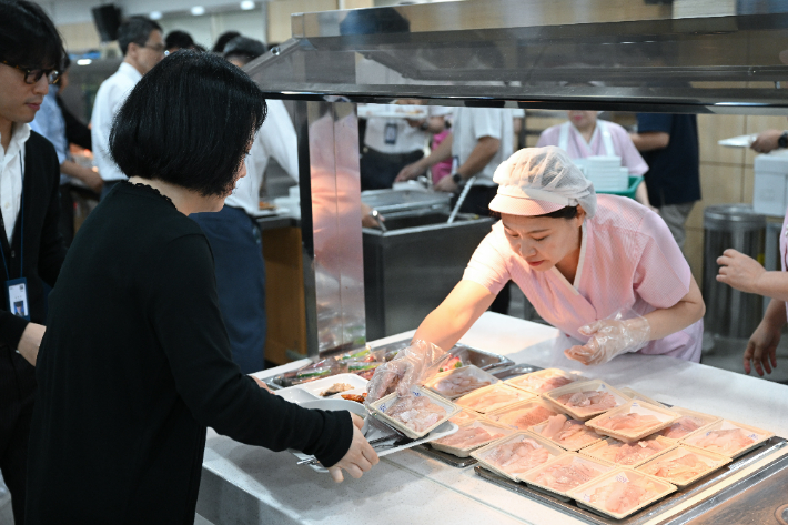  28일 서울 용산 대통령실 청사에서 직원들이 우리 수산물 메뉴로 구성된 점심 식사를 배식받고 있다. 연합뉴스 