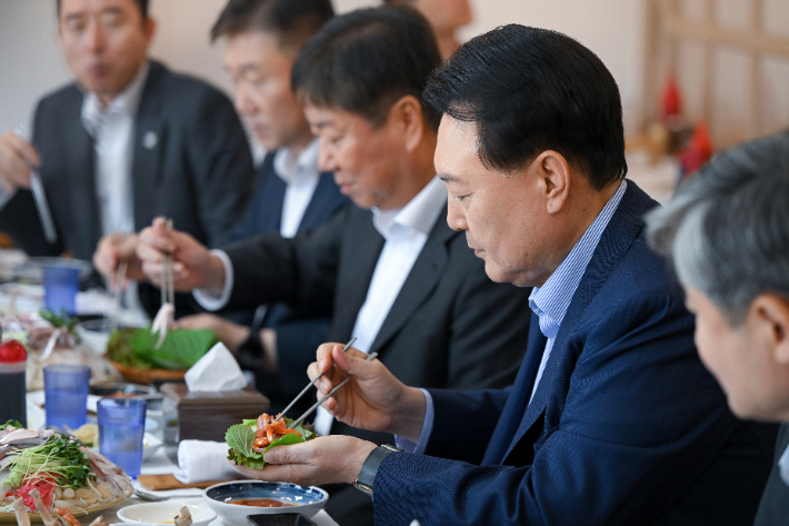 윤석열 대통령이 31일 서울 동작구 노량진수산시장에서 구매한 우리 수산물로 점심식사를 하고 있다. 연합뉴스