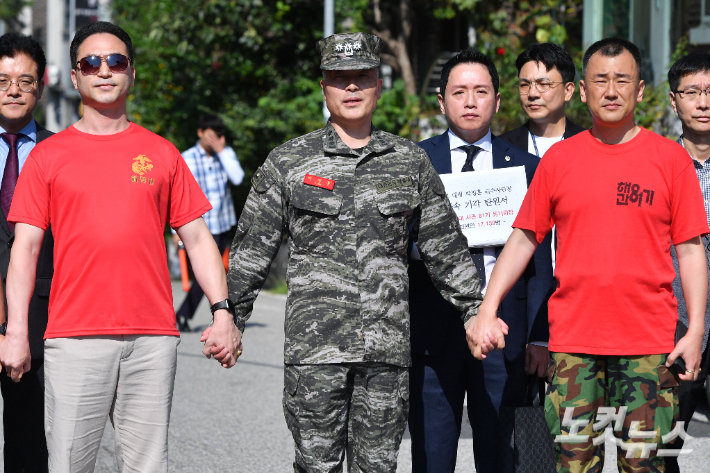 채 모 상병 순직 사건을 수사하다 항명 혐의로 입건된 박정훈 전 해병대 수사단장(대령)이 1일 오전 영장실질심사를 받기 위해 서울 용산구 군사법원으로 들어가기 전 해병대 예비역 동기생들과 손을 맞잡고 있다. 류영주 기자