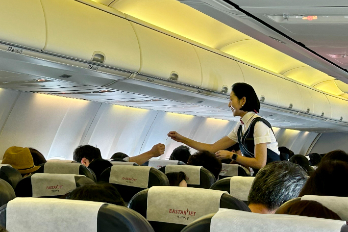 이스타항공 승무원이 대만 송산공항으로 향하는 ZE887편 기내에서 승객들과 함께 이벤트를 진행하고 있다. 이스타항공 제공
