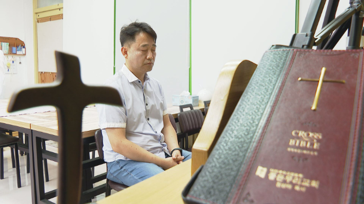 장상태목사가 삶에 지친 사람들의 회복을 위해 기도하는 모습