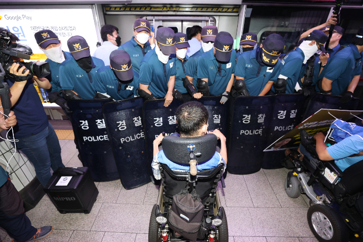 5일 오전 서울 중구 시청역에서 전국장애인차별철폐연대가 연 '출근길 지하철 탑니다 선포 기자회견'에서 참가자들이 지하철에 탑승하려 하자 경찰이 이를 막고 있다. 연합뉴스