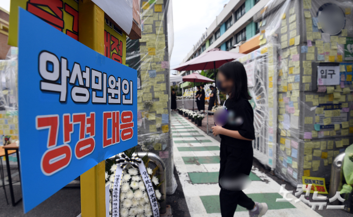 서울 양천구의 한 초등학교 정문에 마련된 교사 A씨 추모공간을 방문한 시민들이 헌화를 하고 있다. 황진환 기자