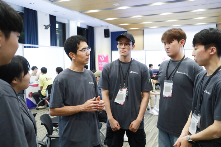 이홍락 LG AI연구원 CSAI(최고 AI 과학자, 왼쪽 세번째)가 LG 에이머스 해커톤에 참가한 청년들과 대화하고 있다. LG 제공