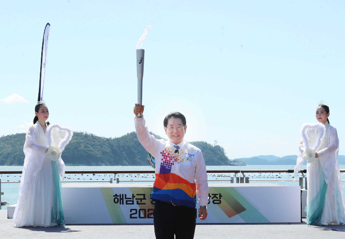 김영록 전라남도지사가 18일 오전 해남군 송지면 땅끝 맴섬광장에서 열린 제104회 전국체전과 제43회 전국장애인체전 성공 개최를 위한 성화 특별채화식에서 칠선녀에 의해 채화된 성화를 전달받고 있다. 전라남도 제공