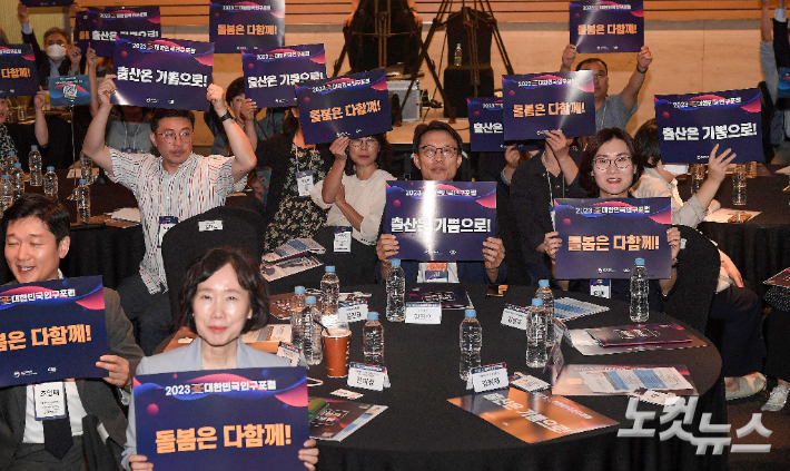 18일 서울 여의도 전경련회관에서 열린 2023 대한민국 인구포럼에서 참석자들이 피켓 세리머니를 하고 있다. 박종민 기자