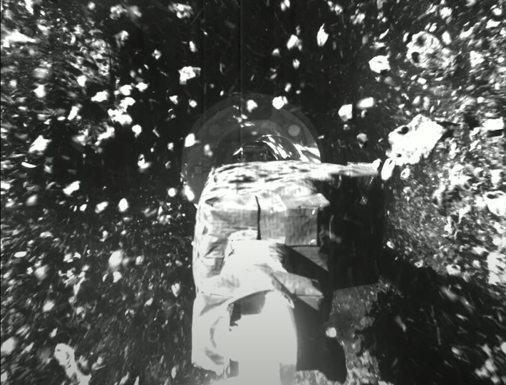 오시리스렉스 탐사선의 로봇팔이 소행성 '베누'의 표면에서 샘플을 채취하는 모습. NASA 유튜브 캡처