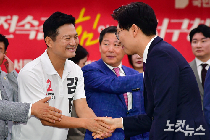 지난달 21일 서울 강서구 곰달래 문화복지센터에서 열린 국민의힘 '동행 서약식'에서 김태우 강서구청장 보궐선거 후보와 합당을 선언한 시대전환 조정훈 의원(오른쪽)이 악수를 하고 있다. 윤창원 기자