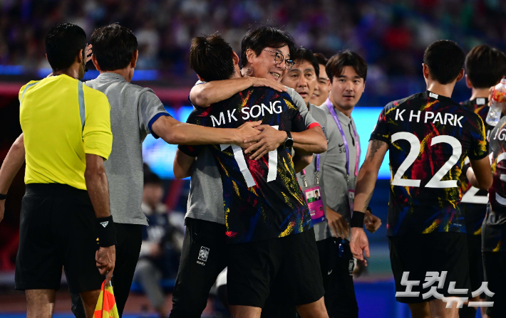 축구 대표팀 송민규가 1일 오후 중국 항저우 황룽 스포츠센터 스타디움에서 열린 '2022 항저우 아시안게임' 축구 8강전 중국과의 경기에서 두 번째 골을 성공시킨 후 황선홍 감독고 포옹하고 있다. 항저우(중국)=황진환 기자