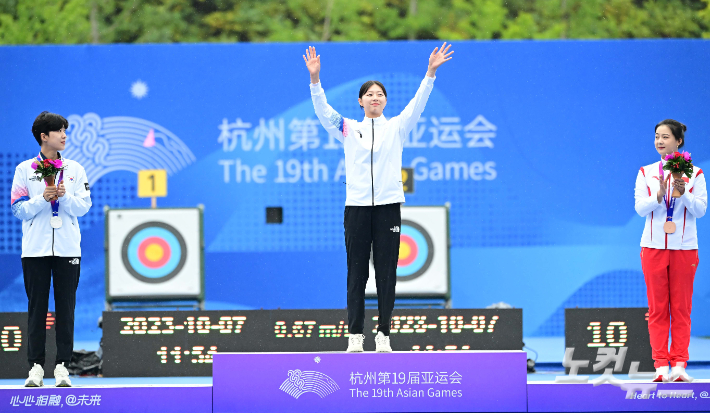 7일 중국 항저우 푸양 인후 스포츠센터에서 열린 2022 항저우 아시안게임 양궁 리커브 여자 개인 결승전에서 금메달을 획득한 임시현(가운데)이 시상대에 올라 손을 흔들고 있다. 항저우(중국)=황진환 기자