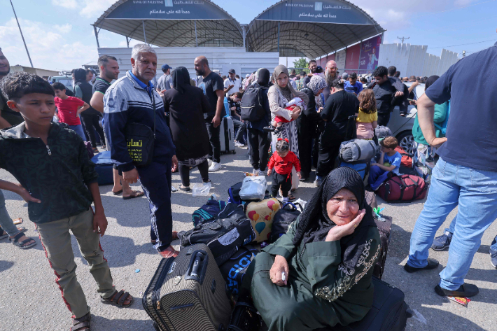 이집트로 대피하려는 팔레스타인인들과 지원을 기다리는 사람들이 16일(현지시간) 가자지구 남부 '라파 국경 통행로'에서 대기하고 있다. 연합뉴스