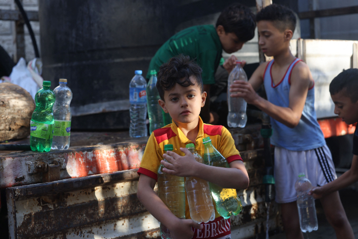 트럭에서 식수 받아가는 팔레스타인 어린이들. 연합뉴스