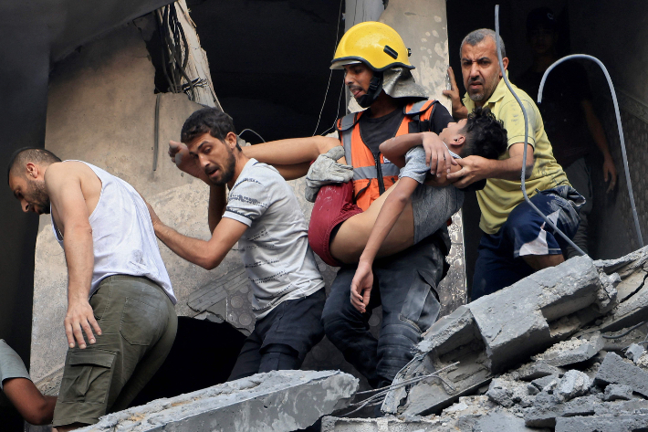 팔레스타인 무장 정파 하마스와 이스라엘 간 무력 충돌이 계속되는 가운데 19일(현지시간) 이스라엘 공습으로 파손된 가자지구 칸 유니스 건물에서 시민방위대원과 주민들이 생존자를 구조하고 있다. 