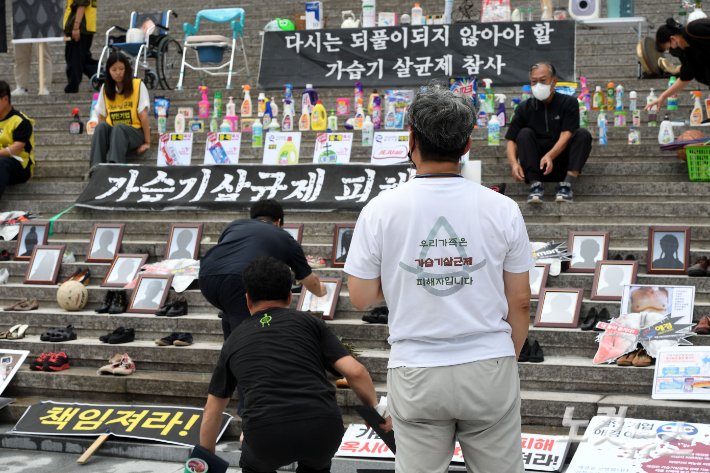 지난해 8월 가습기살균제 참사가 알려진지 11년이 되는 날 희생자 가족들이 서울 종로구 세종문화회관 계단에서 고인들의 유품을 전시하고 있다. 황진환 기자