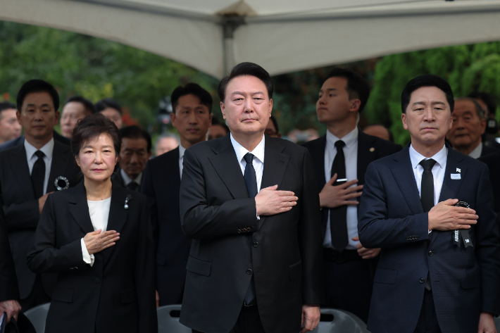 윤석열 대통령이 26일 서울 동작구 국립서울현충원 박정희 전 대통령 묘역에서 열린 박 전 대통령 서거 제44주기 추도식에서 국기에 경례하고 있다. (왼쪽부터)박근혜 전 대통령, 윤 대통령, 국민의힘 김기현 대표. 