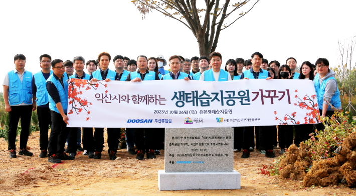 지난 26일 익산시 유천생태습지공원에서 진행된 '생태습지공원 가꾸기' 사회공헌활동을 마치고 두산퓨얼셀 임직원들이 단체사진을 촬영하고 있다. 두산퓨얼셀 제공