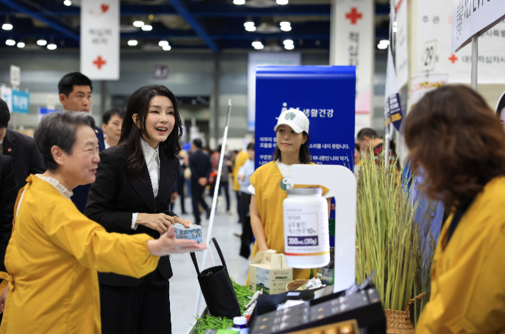 김건희 여사가 31일 서울 강남구 코엑스에서 열린 2023 적십자 바자 행사에서 물품을 구매하고 있다. 대통령실 제공