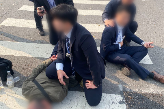 31일 오후 서울 용산구 대통령실 외곽에서 근무 중이던 경찰관 2명이 박 모 씨가 휘두른 흉기에 찔리는 일이 발생했다. 경찰이 흉기를 휘두른 박 씨(왼쪽)를 체포하고 있다. 오른쪽은 부상한 경찰관. 경찰 제공