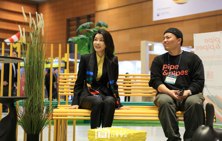김건희 여사가 1일 서울 강남구 코엑스에서 열린 디자인코리아 2023 개막식에서 친환경 플라스틱 코팅 스틸 파이프로 만든 파이프앤파입스의 의자를 살펴보고 있다. 대통령실 제공.