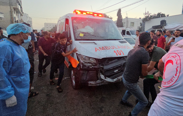 3일(현지시간) 가자시티 알시파 병원 입구에서 팔레스타인인들이 공습으로 파손된 구급차를 끌고 있다. 가자지구 보건부는 이날 중상자를 이송하던 구급차 행렬이 공습을 받아 15명이 숨지고 60여명이 다쳤다고 주장했다. 연합뉴스