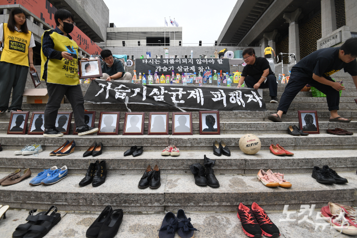 지난해 8월 가습기살균제 참사가 알려진지 11년이 되는 날 희생자 가족들이 서울 종로구 세종문화회관 계단에서 고인들의 유품을 전시하고 있다. 황진환 기자