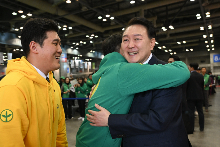 윤석열 대통령이 12일 경기 고양시 킨텍스에서 열린 2023 전국새마을지도자대회 '청년의 약속' 선포식에서 한 청년을 안아주고 있다. 연합뉴스 