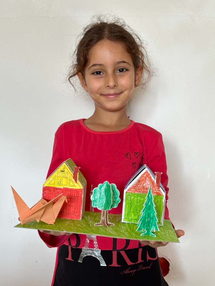 아이프칠드런 튀르키예 국제 예술나눔 현장프로그램 수업에 참여한 아이가 완성한 작품을 들고 행복한 미소를 짓고 있다. 아이프칠드런 제공 